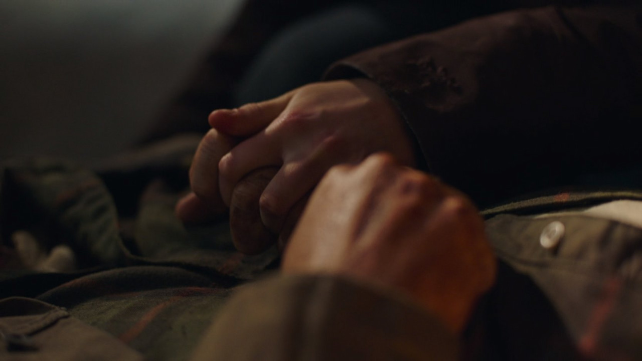 Ellie (Bella Ramsey) e Joel (Pedro Pascal) de mãos dadas no episódio "Left Behind".