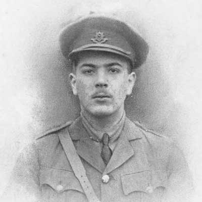 Imagem histórica de um jovem soldado militar em uniforme antigo, usando chapéu e expressão séria.