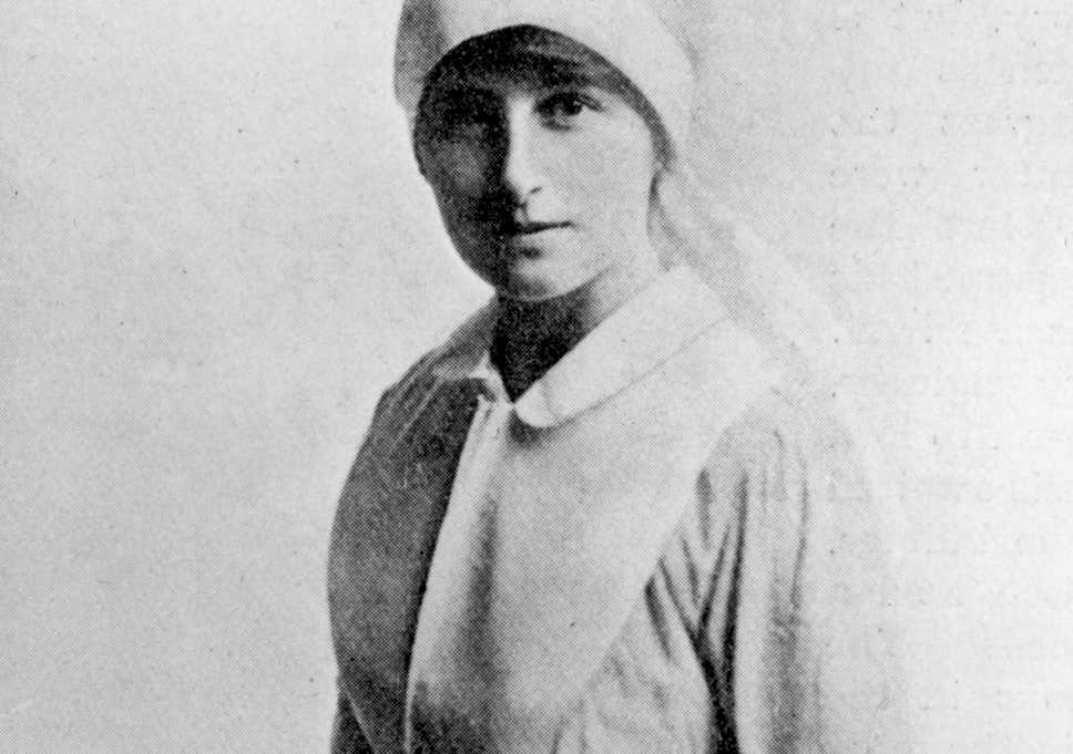 Imagem de mulher (Vera Brittain) com chapéu, vestindo camisa de manga longa, em preto e branco, com expressão séria e olhar direto para a câmera.