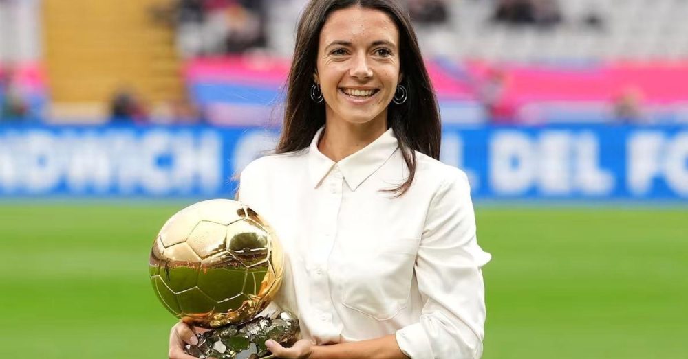 Mulher feliz segurando uma taça dourada de futebol, em um estádio, celebrando uma vitória no futebol feminino.