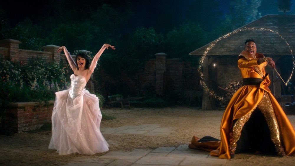 Casal dançando feliz ao ar livre à noite, com a mulher usando vestido branco de baile e o homem em fantasia dourada, celebrando momentos especiais.